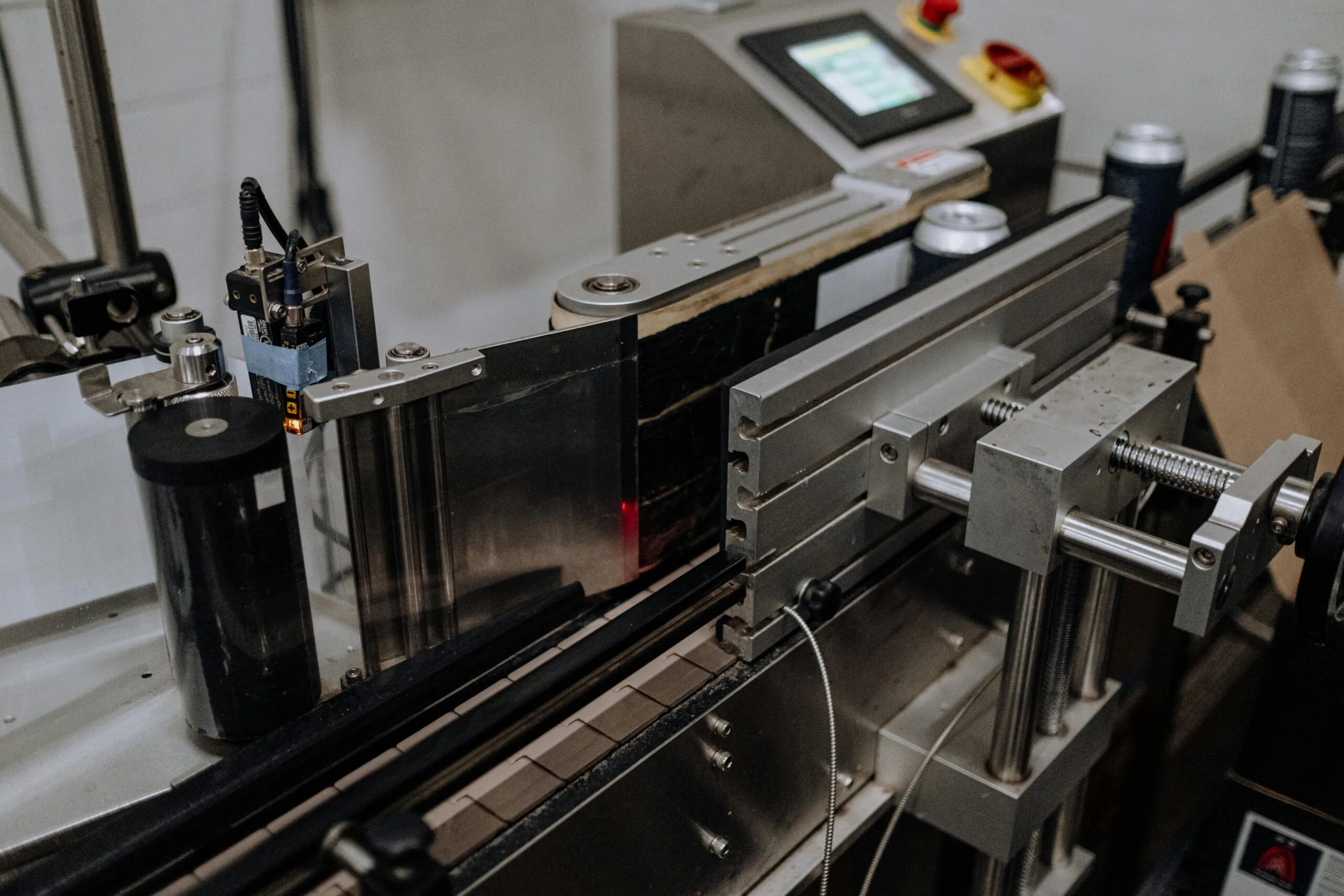 Close-up of automated canning equipment in a modern brewery assembly line.